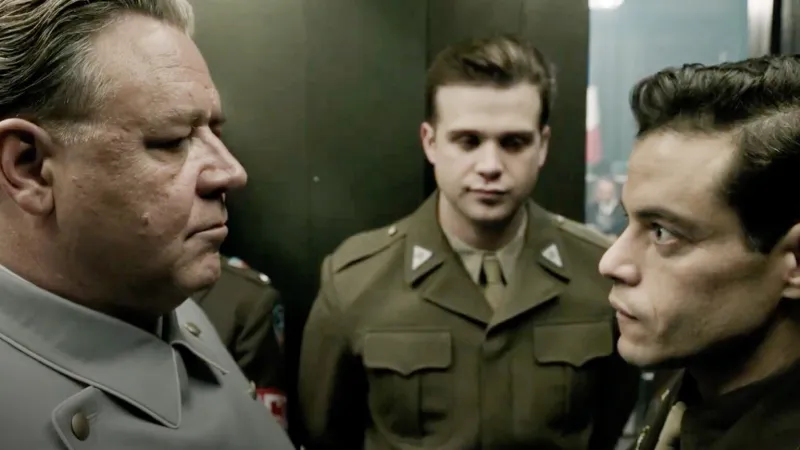 Russell Crowe as former Reichsmarschall Hermann Göring, stands face-to-face with Remi Malek as Dr. Douglas Kelley.